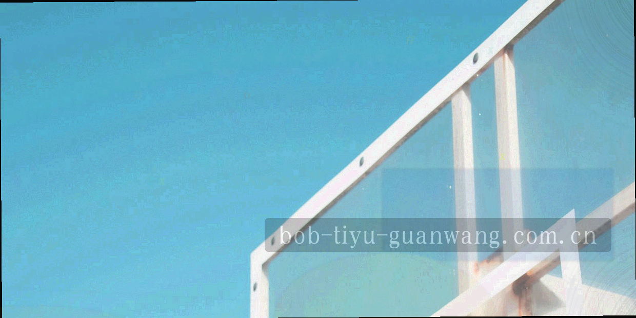 训练基地外景，球场边线与围栏形成清晰的几何切割，天色偏冷